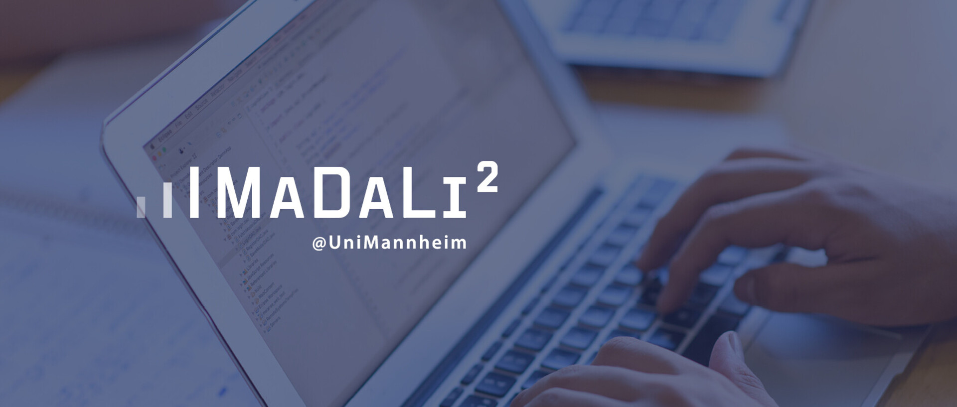 Eine Person, deren Hände im Bild sind, schreibt am Laptop. Über das Bild ist das "MaDaLi²"-Logo in weißer Schrift und blauem Hintergrund gelegt.