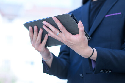 Eine Frau hält ein Tablet in ihren Händen.