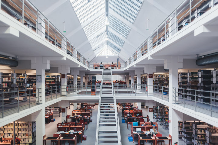Blick in den Bibliotheksbereich A3 mit Galerien, großer Treppe, Bücherregalen und Arbeitsplätzen.